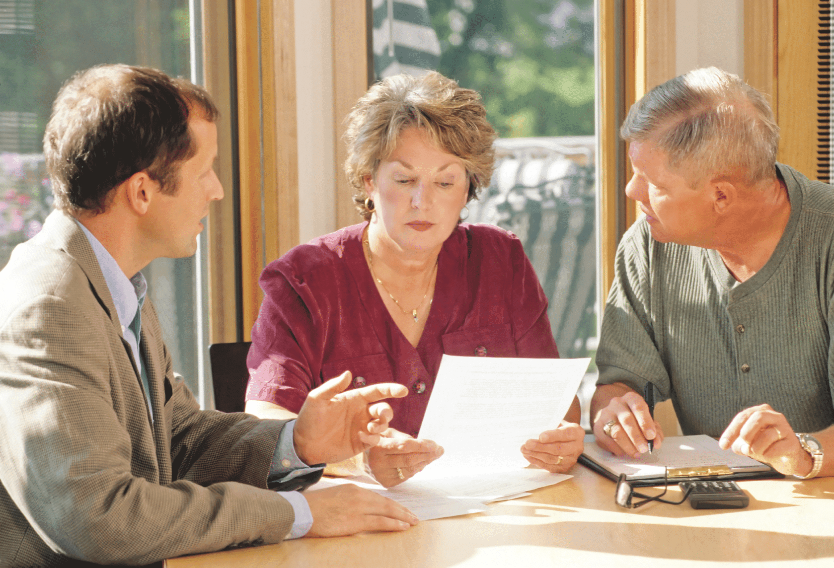 Mature couple talking to financial planner at home
